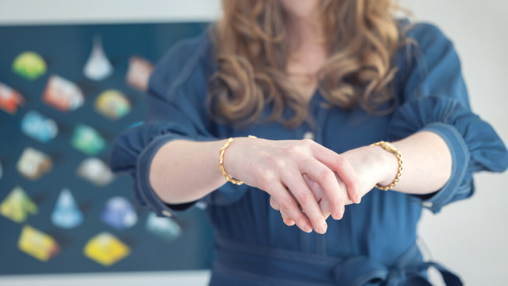 Kathryn Kissell holds her hands together with one gripped tightly into the other's grasp — illustrating fusion, where individuality is absorbed rather than held alongside connection.